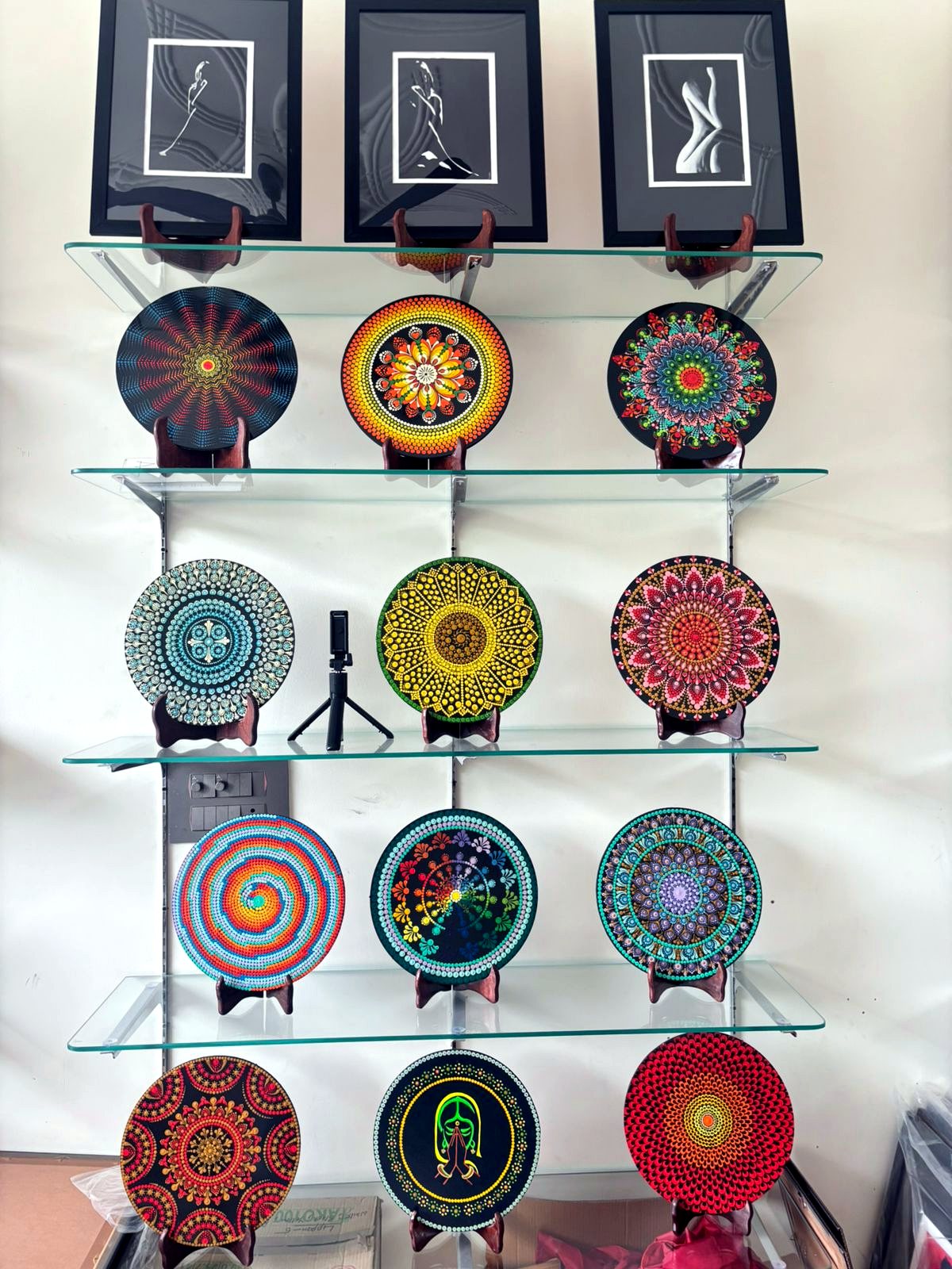 Dot mandala plates displayed on a glass shelf