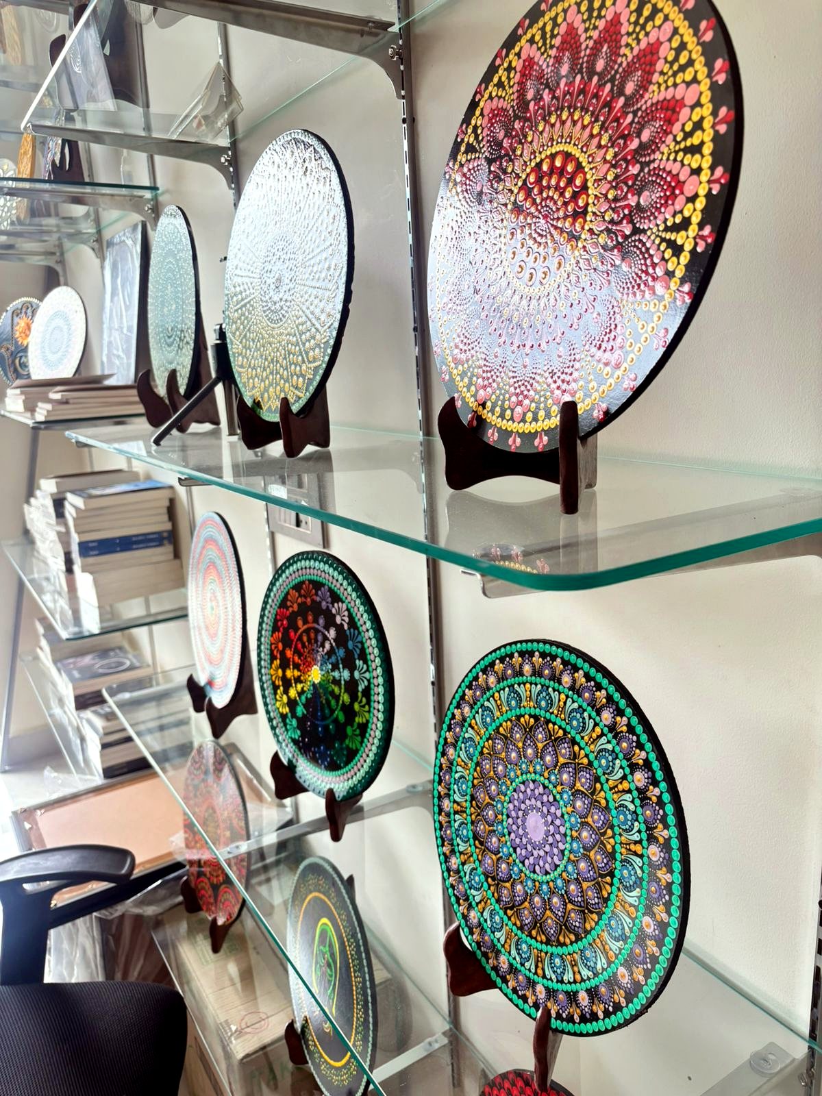 Mandala artwork plates on glass shelves