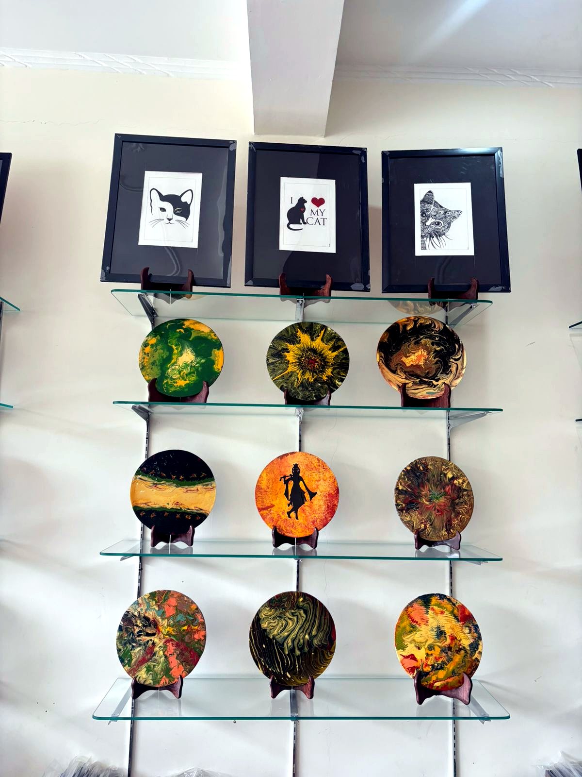 Framed drawings and round artworks on display